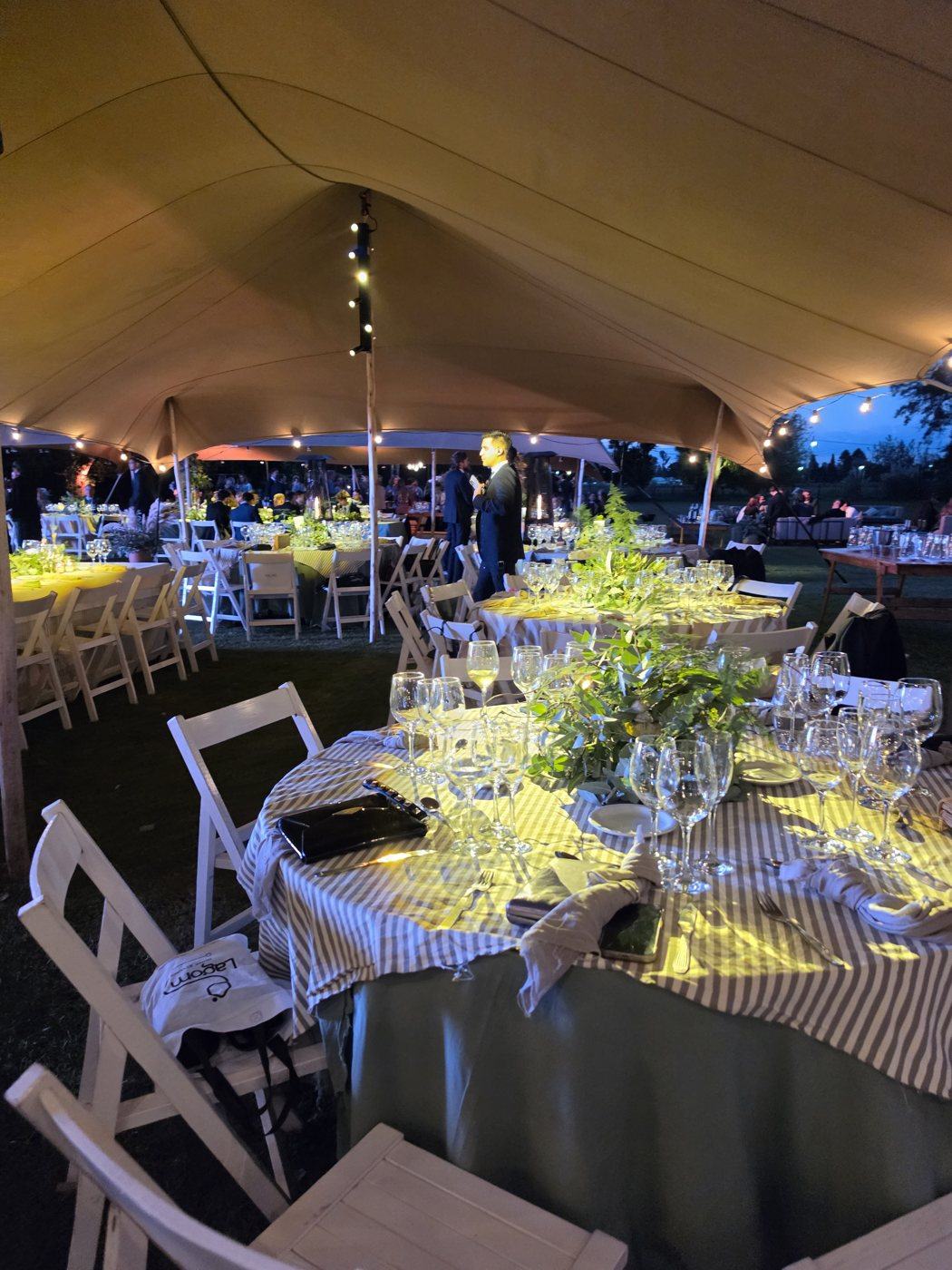 Cena de evento con mesas iluminadas al aire libre