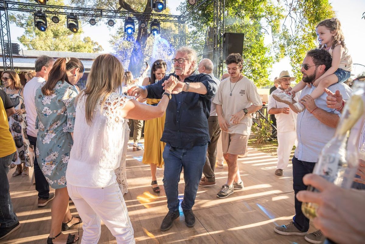 Jorge bailando en la pista rodeado de invitados, con un ni&ntilde;o en andas al costado