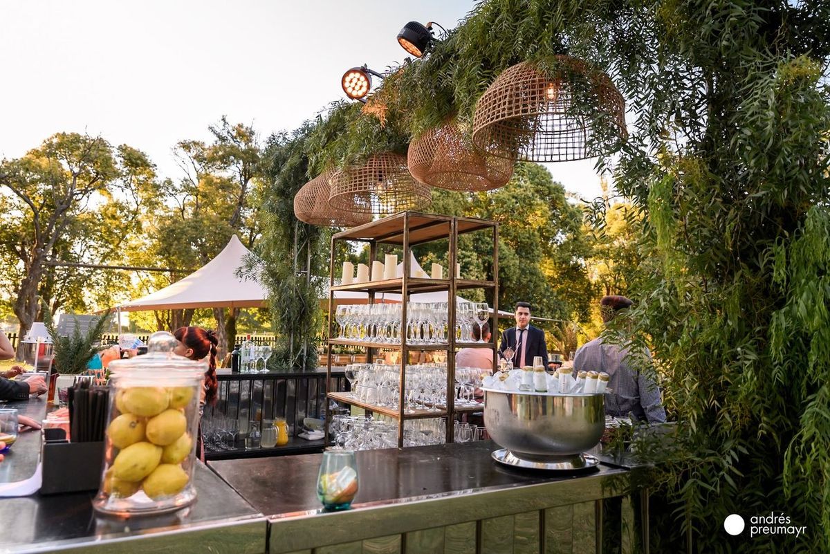 Puesto gastron&oacute;mico y barra iluminada con pinspots entre la vegetaci&oacute;n del parque