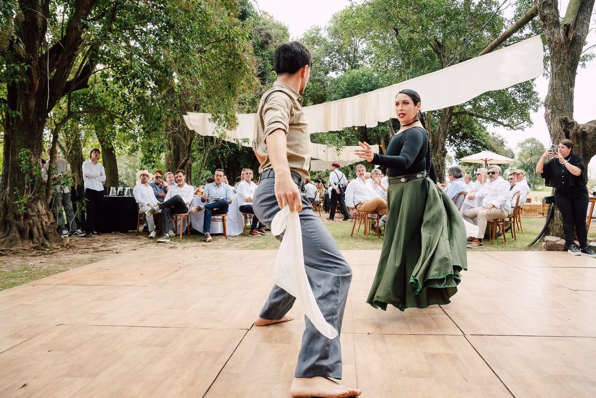 Pareja de baile folkl&oacute;rico frente a los invitados sentados en el almuerzo de campo