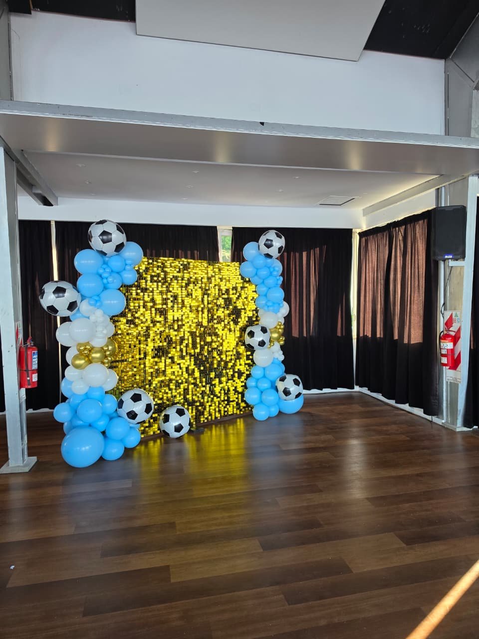 Ambientación con arco de globos y muro de lentejuelas