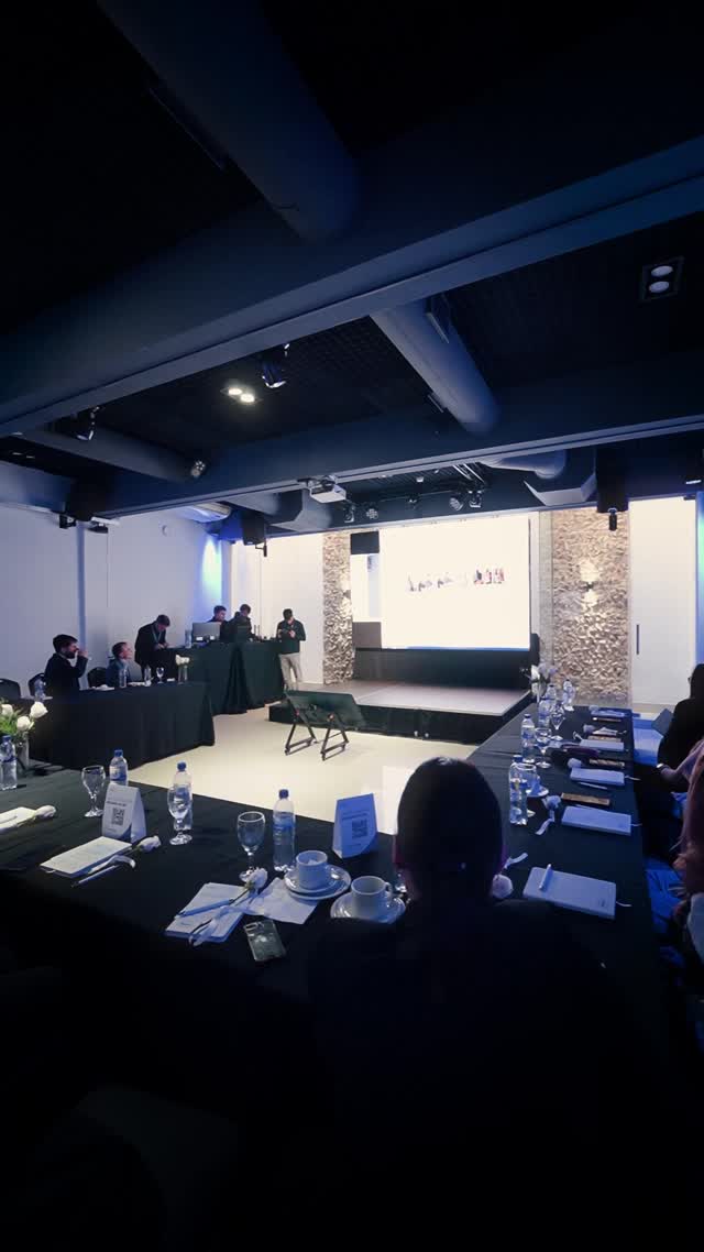 Evento corporativo con pantalla y asistentes