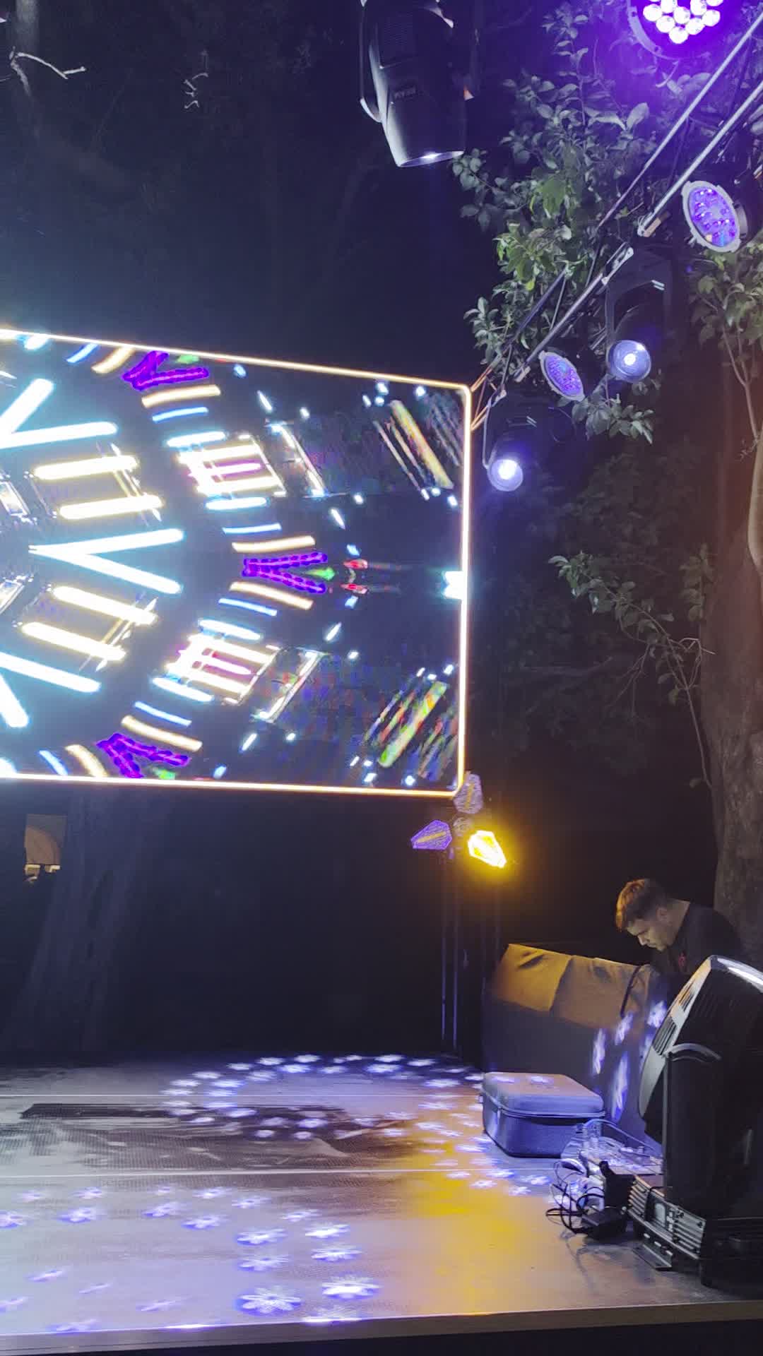 Escenario en parque con luces y pantalla LED de noche