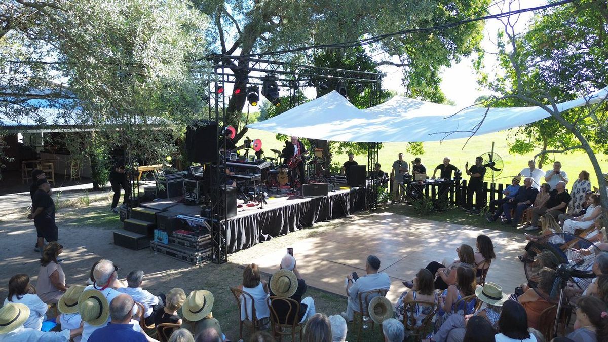 Vista a&eacute;rea del escenario montado por GS T&eacute;cnica en el cumplea&ntilde;os de Jorge: truss, luces y lona sobre el campo, con la banda tocando y el p&uacute;blico sentado bajo los &aacute;rboles